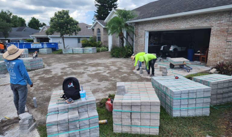 Workerse installing pavers outside of a home.
